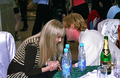 A photo of a Russian woman conversing with a western man at a social gathering