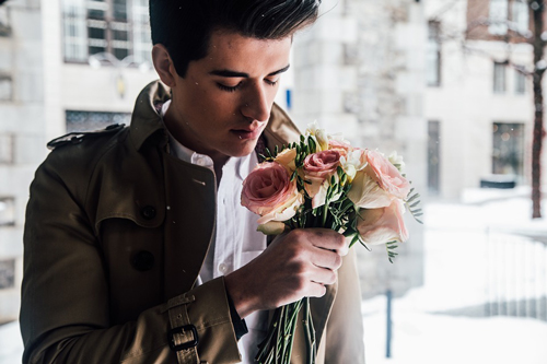 A man holding flowers looking to woo Russian women.